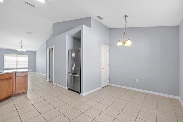 kitchen with stainless steel fridge, light tile patterned floors, and a notable chandelier