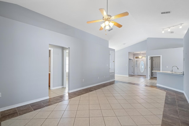 unfurnished room with light tile patterned floors, ceiling fan, lofted ceiling, and sink