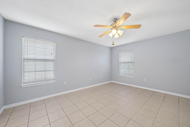 spare room with light tile patterned floors, a textured ceiling, and ceiling fan