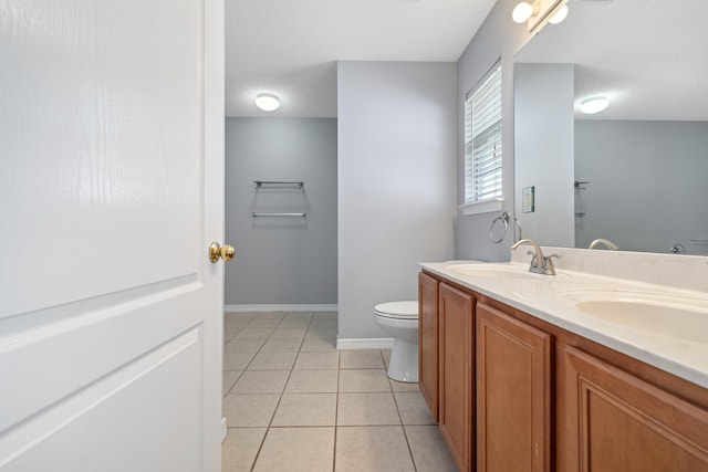 bathroom featuring tile patterned flooring, vanity, toilet, and a textured ceiling