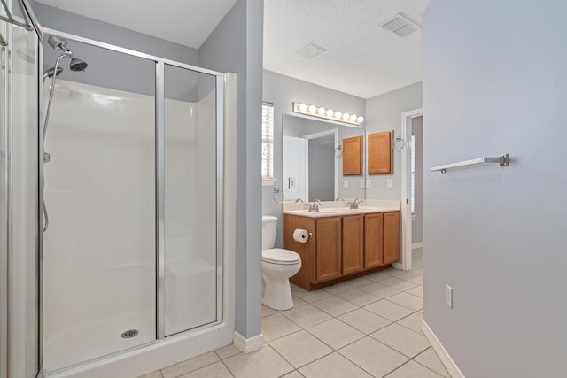 bathroom featuring vanity, tile patterned floors, toilet, a textured ceiling, and an enclosed shower