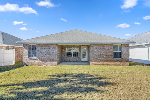 back of property featuring a lawn and a patio