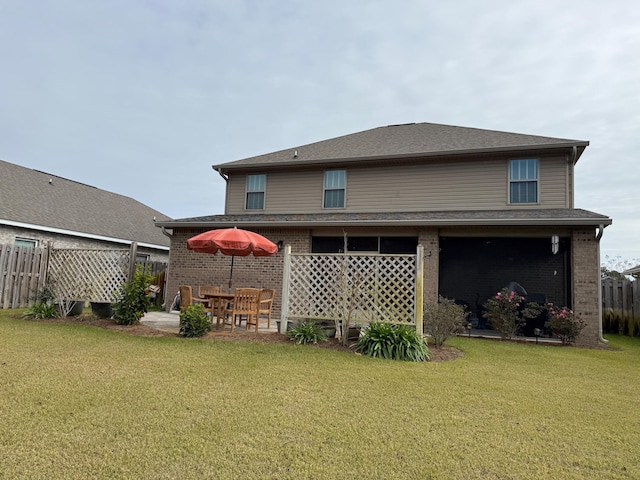 rear view of house featuring a yard and a patio