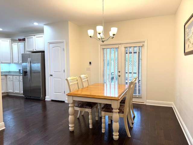 dining space featuring dark wood-type flooring, french doors, and an inviting chandelier