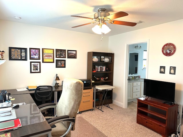 carpeted office space featuring ceiling fan