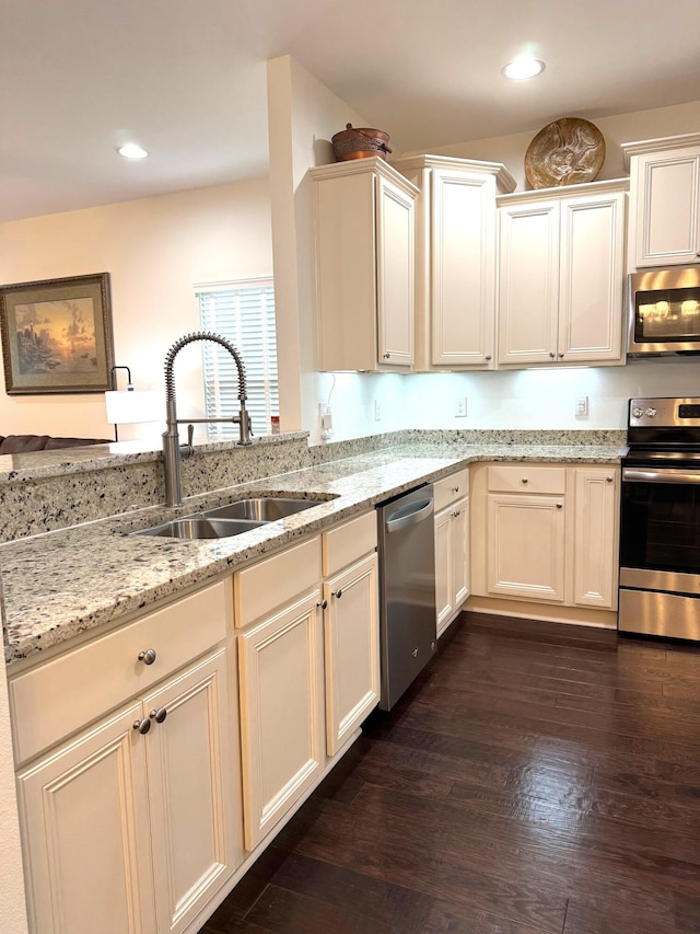 kitchen with light stone countertops, sink, dark hardwood / wood-style floors, and stainless steel appliances