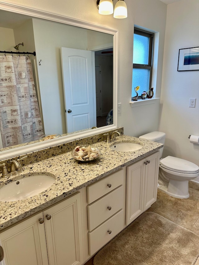 bathroom with toilet, vanity, and curtained shower