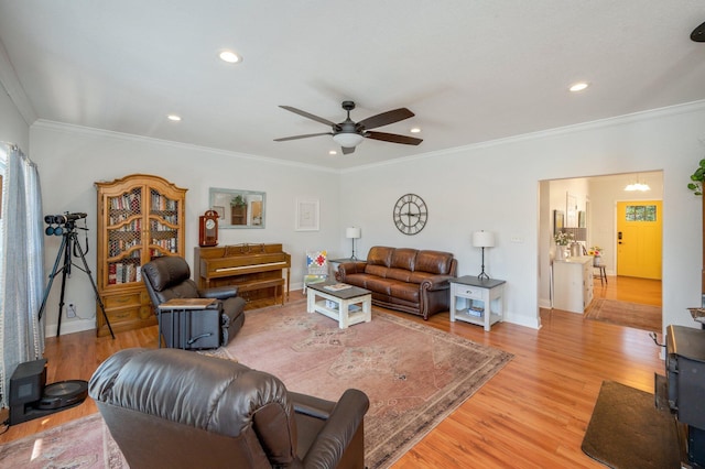 living room featuring ceiling fan, light hardwood / wood-style floors, and ornamental molding