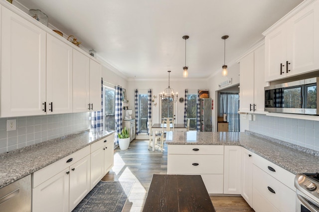 kitchen featuring pendant lighting, light stone counters, white cabinetry, and stainless steel appliances