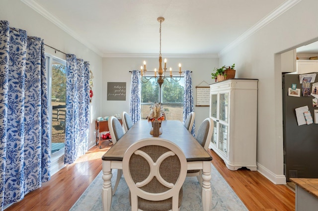 dining space featuring ornamental molding, light hardwood / wood-style flooring, and a chandelier