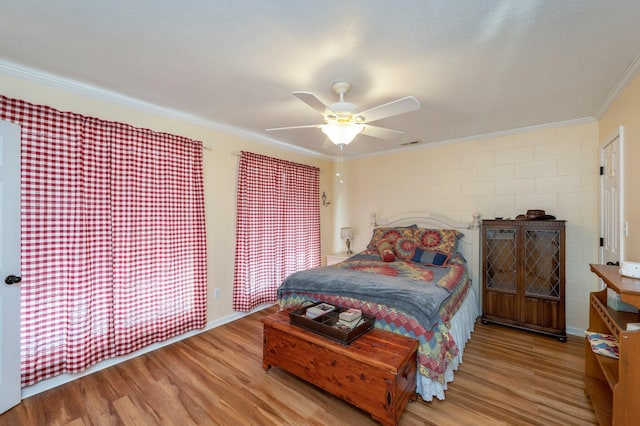 bedroom with light hardwood / wood-style floors, ceiling fan, and ornamental molding