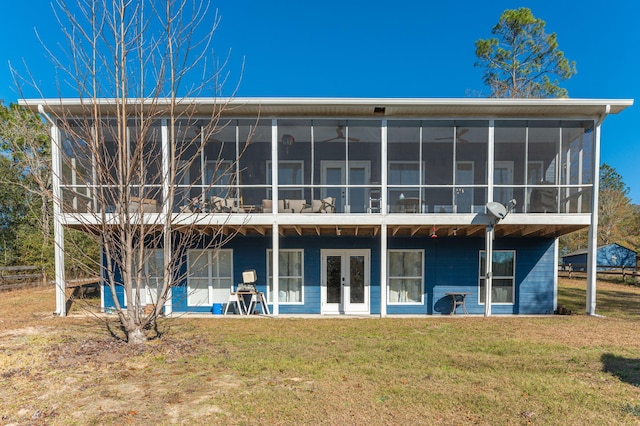 rear view of house with a sunroom, a yard, and french doors