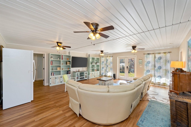 living room with french doors, built in features, and light wood-type flooring