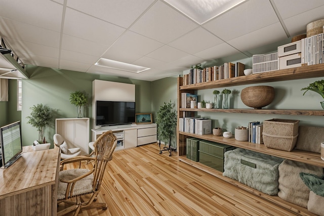 office area with a paneled ceiling and light hardwood / wood-style floors