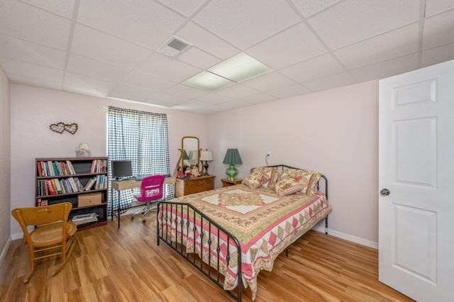 bedroom featuring a paneled ceiling and hardwood / wood-style flooring