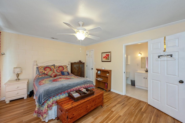 bedroom with ornamental molding, ceiling fan, connected bathroom, light hardwood / wood-style floors, and a closet