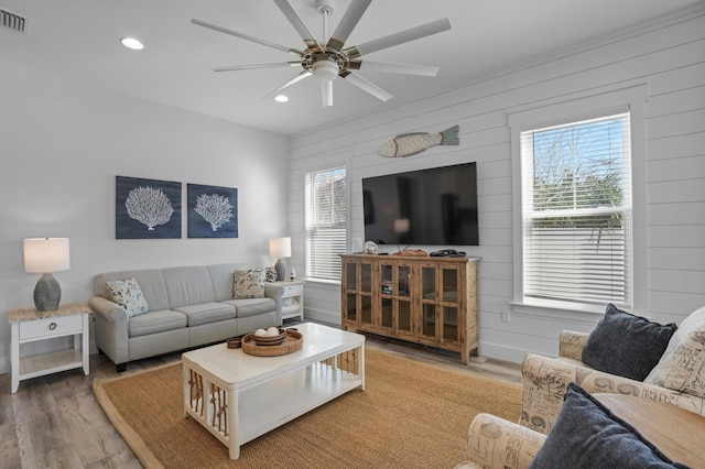 living room with wooden walls, a healthy amount of sunlight, and hardwood / wood-style flooring