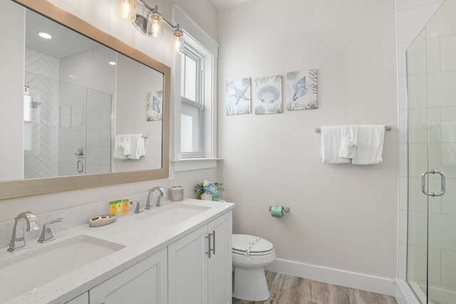 bathroom featuring toilet, vanity, wood-type flooring, and walk in shower