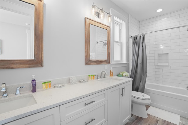 full bathroom featuring vanity, hardwood / wood-style flooring, shower / tub combo with curtain, and plenty of natural light