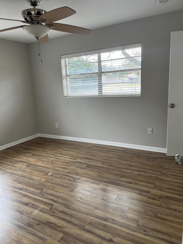 empty room with dark hardwood / wood-style flooring and ceiling fan