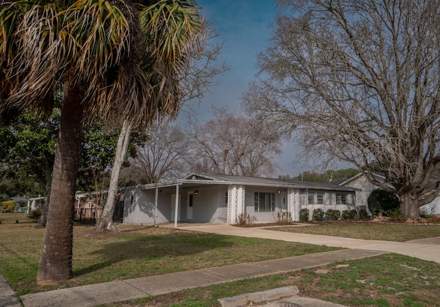 view of front of property featuring a front lawn and a carport