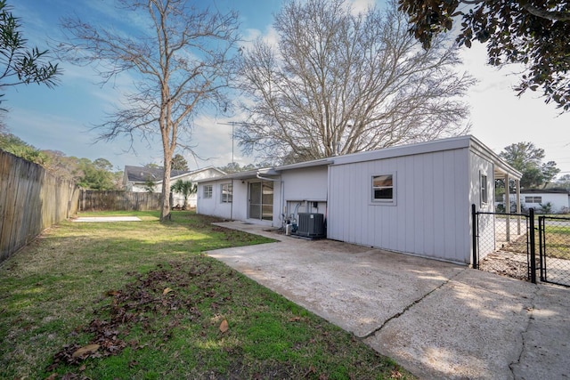 rear view of house featuring a yard, a patio, and central air condition unit