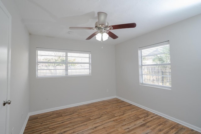 unfurnished room with a healthy amount of sunlight, hardwood / wood-style floors, and ceiling fan