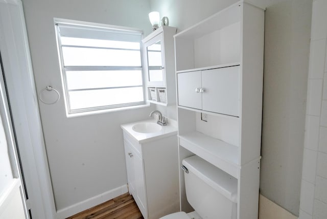 bathroom featuring vanity, hardwood / wood-style flooring, and toilet