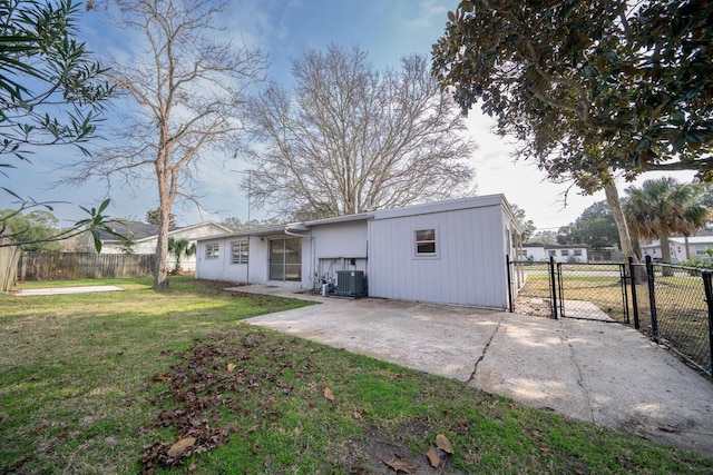 rear view of house with a patio, central AC unit, and a lawn