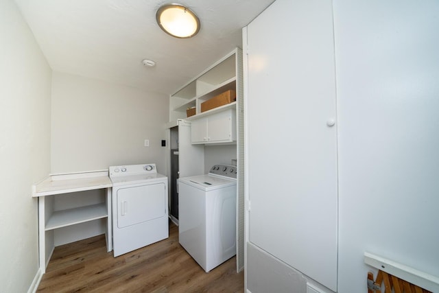 clothes washing area featuring dark wood-type flooring and washing machine and clothes dryer