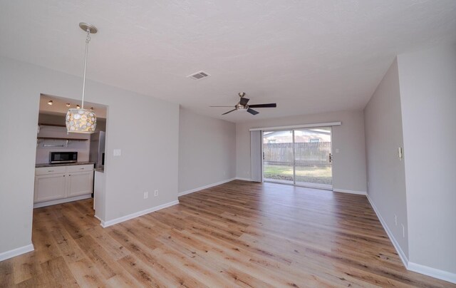 unfurnished living room with ceiling fan and light hardwood / wood-style floors