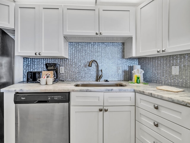 kitchen featuring dishwasher, decorative backsplash, and white cabinetry