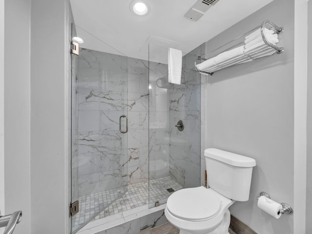 bathroom with toilet and a shower with door