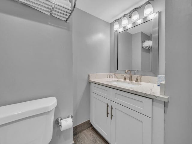 bathroom with hardwood / wood-style flooring, vanity, and toilet