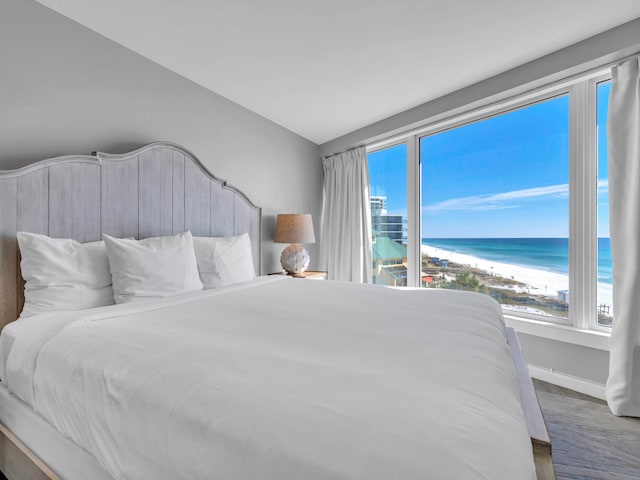 bedroom with a water view and a beach view