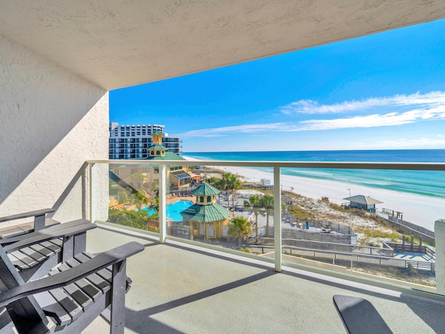 balcony featuring a view of the beach and a water view