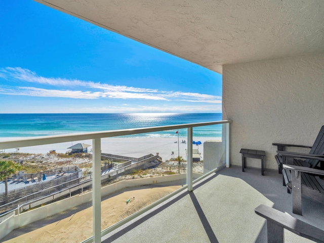 balcony with a water view and a beach view