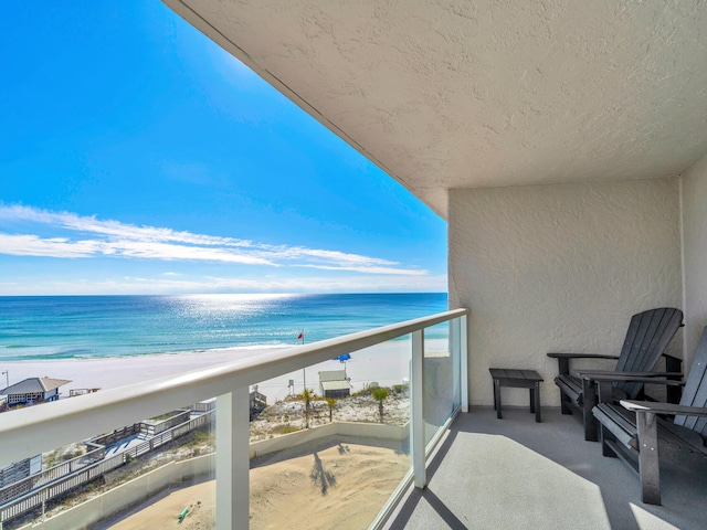 balcony with a water view and a beach view