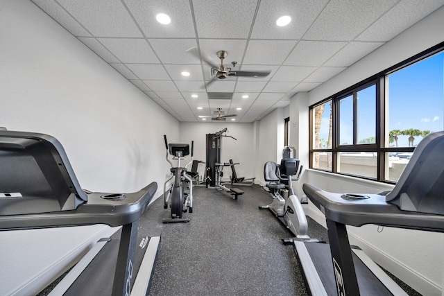 workout area featuring ceiling fan and a drop ceiling