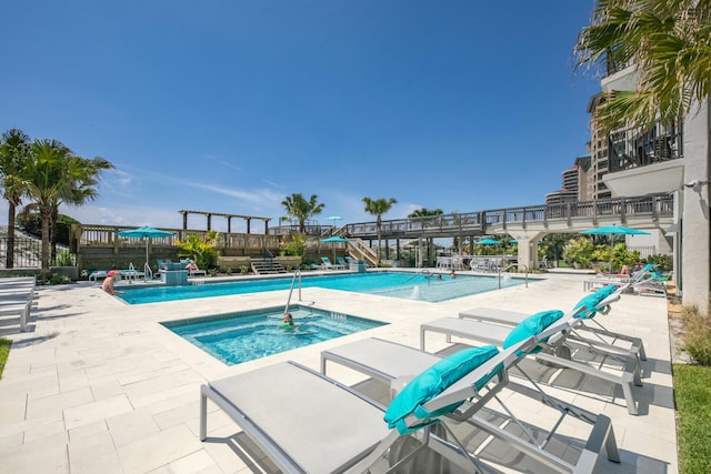 view of pool with a hot tub and a patio area