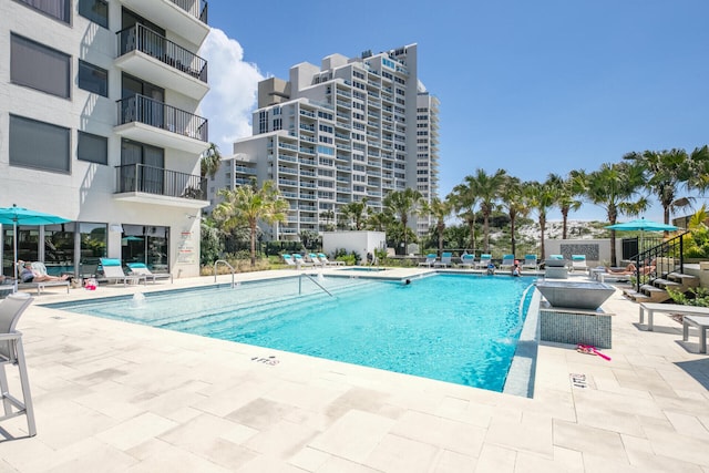 view of swimming pool with pool water feature and a patio