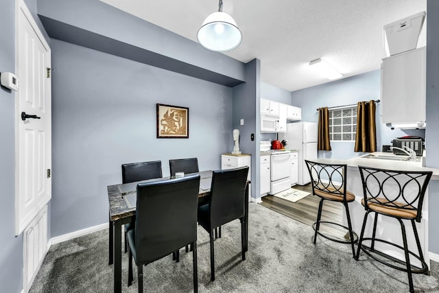 dining room with carpet, sink, and a textured ceiling