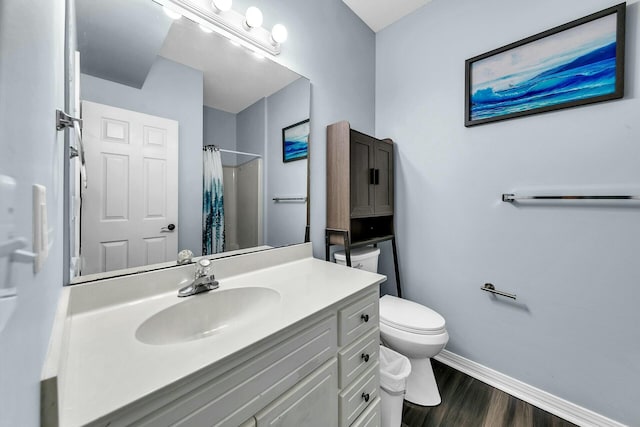 bathroom with hardwood / wood-style floors, toilet, vanity, and a shower with shower curtain