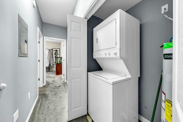 laundry area with light colored carpet, a textured ceiling, electric panel, and stacked washing maching and dryer