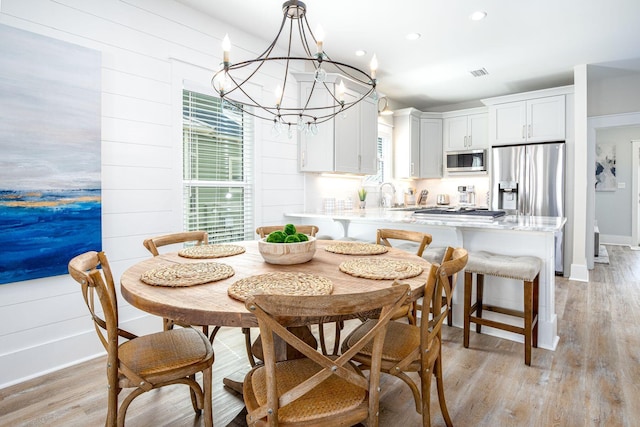 dining room with light hardwood / wood-style floors and sink