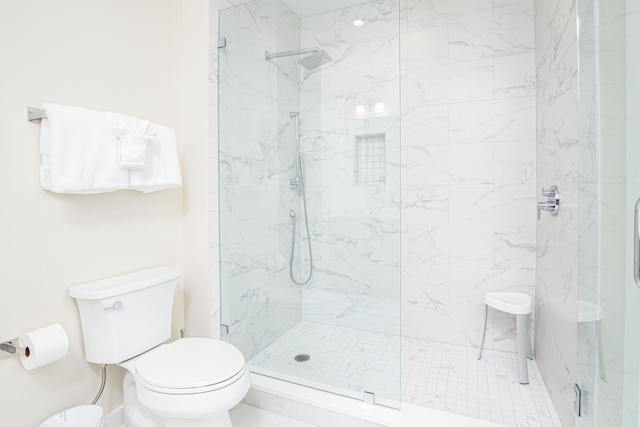 bathroom featuring a tile shower and toilet