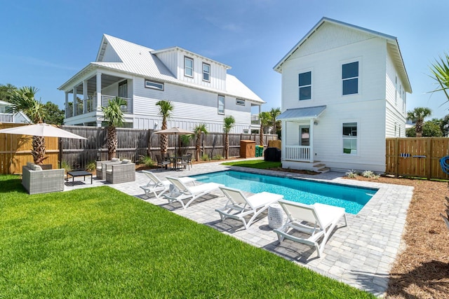 back of house featuring a yard, a fenced in pool, and a patio area