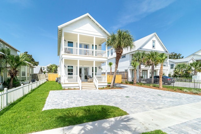 back of property featuring a porch, a yard, a balcony, and french doors