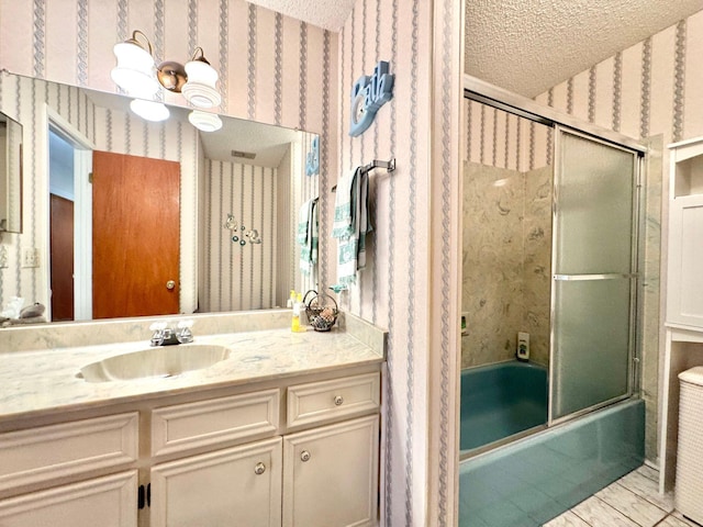 bathroom with vanity, shower / bath combination with glass door, a textured ceiling, and a notable chandelier