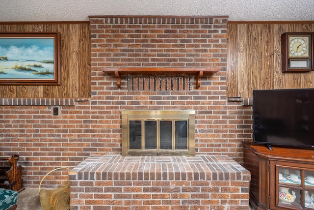 unfurnished living room featuring a fireplace, ornamental molding, wooden walls, and a textured ceiling